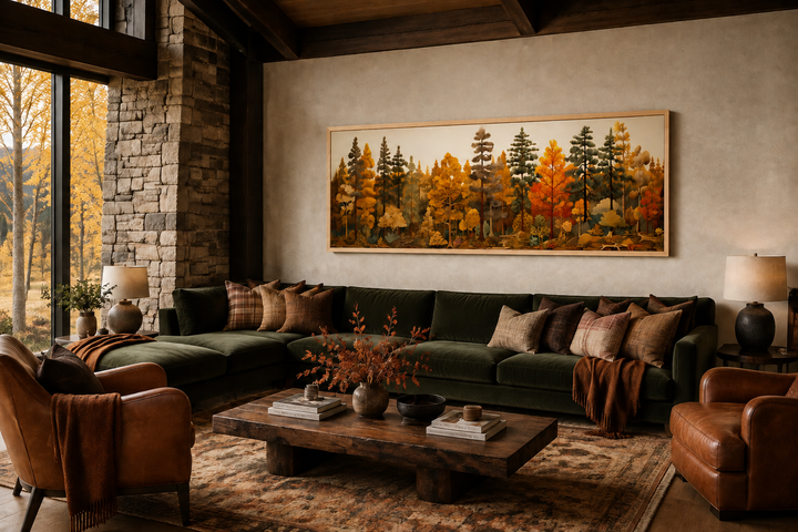 Long horizontal autumn forest painting on wood wall art above a green sofa in a rustic cabin.