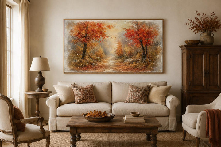 Autumn forest wall art with orange and rust trees in a misty woodland scene above a beige sofa.