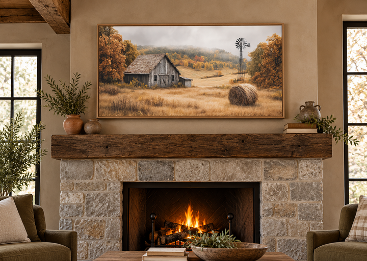 Rustic barn, hay bale, and windmill in a fall landscape canvas wall art above a stone fireplace.