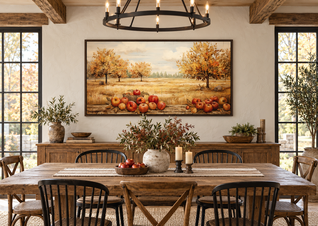Autumn apple orchard painting on a farmhouse dining room wall above a rustic wooden table.