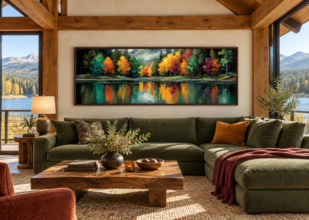 Autumn forest lake reflection long narrow canvas wall art above a green sectional sofa.