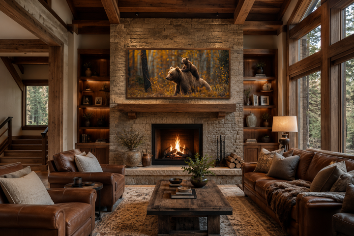Baby bear riding mama bear in autumn forest framed canvas wall art above a fireplace in a cabin.