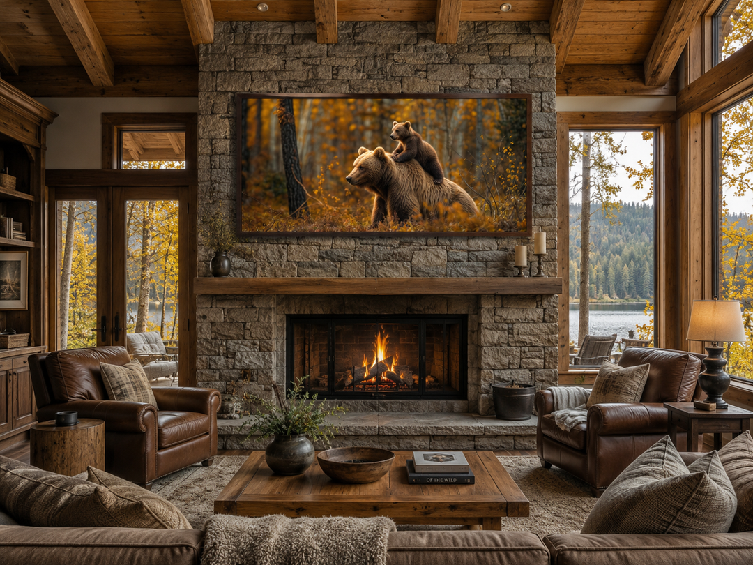 Framed canvas wall art of a baby bear riding a mama bear in an autumn forest above a fireplace.