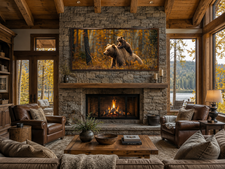 Framed canvas wall art of a baby bear riding a mama bear in an autumn forest above a fireplace.