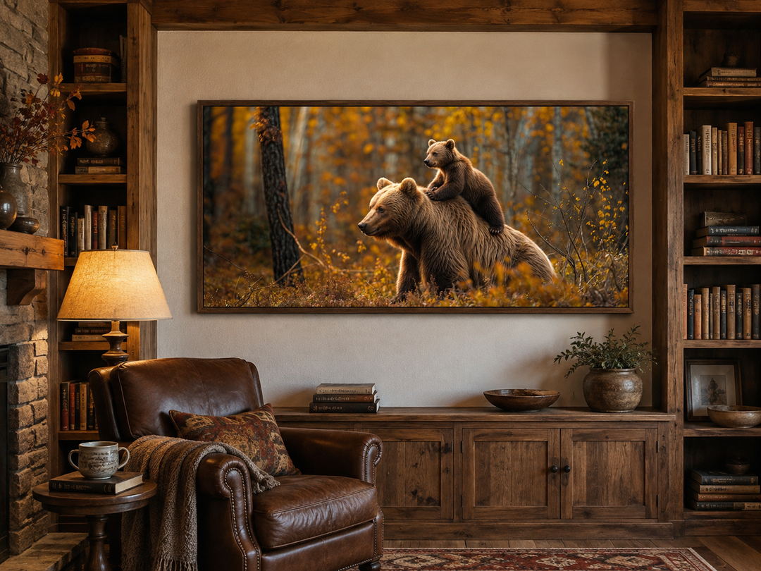 Framed canvas wall art of a baby bear riding a mama bear in an autumn forest above a wooden cabinet.
