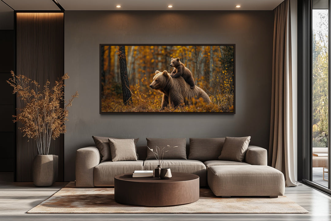Baby bear riding mama bear in autumn forest framed canvas wall art in a modern living room.
