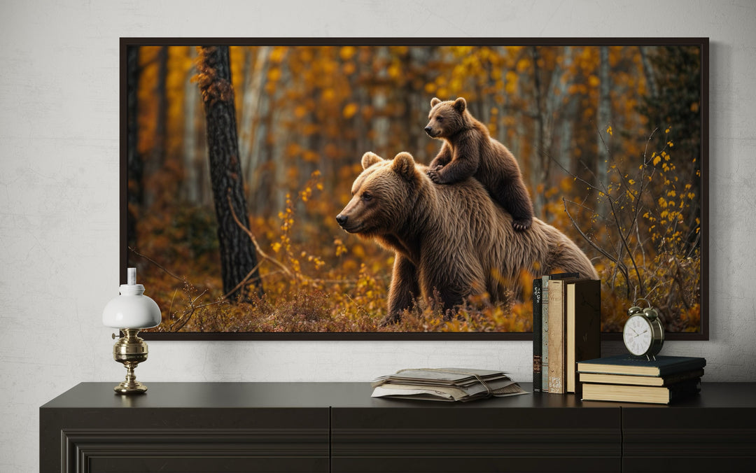Framed canvas art of a baby bear riding on its mother's back in a golden autumn forest.