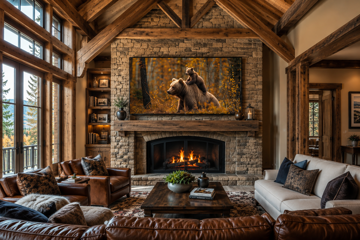 Baby bear riding mama bear in autumn forest framed canvas wall art above a fireplace in a cabin.