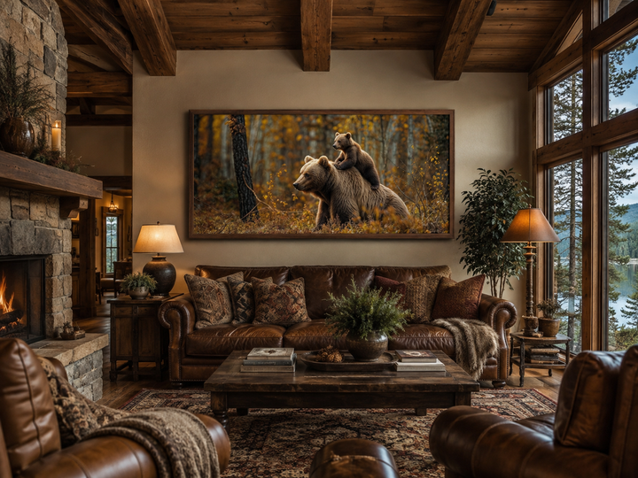 Framed canvas wall art of a baby bear riding a mama bear in an autumn forest above a leather sofa.