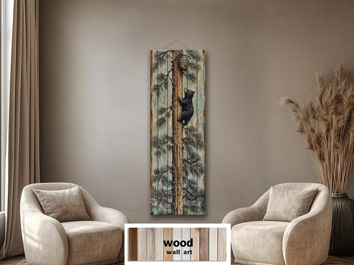 Rustic wood plank wall art of a baby bear climbing a pine tree towards a beehive in a cozy room.