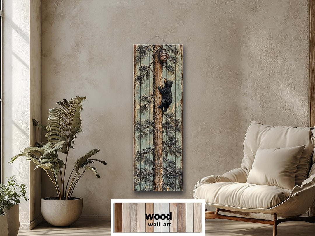 Rustic wood plank wall art of a baby bear climbing a pine tree toward a beehive in a cozy room.