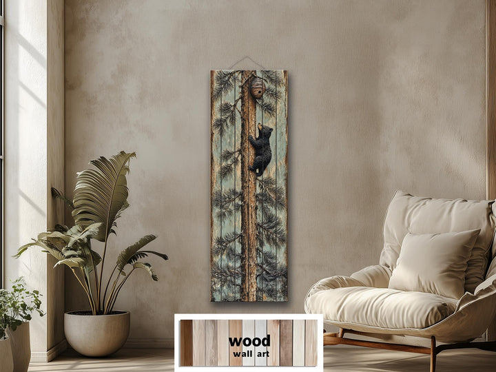 Rustic wood plank wall art of a baby bear climbing a pine tree toward a beehive in a cozy room.