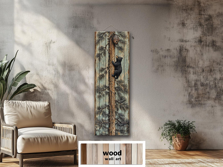 Rustic wood plank wall art featuring a baby bear climbing a pine tree towards a beehive.