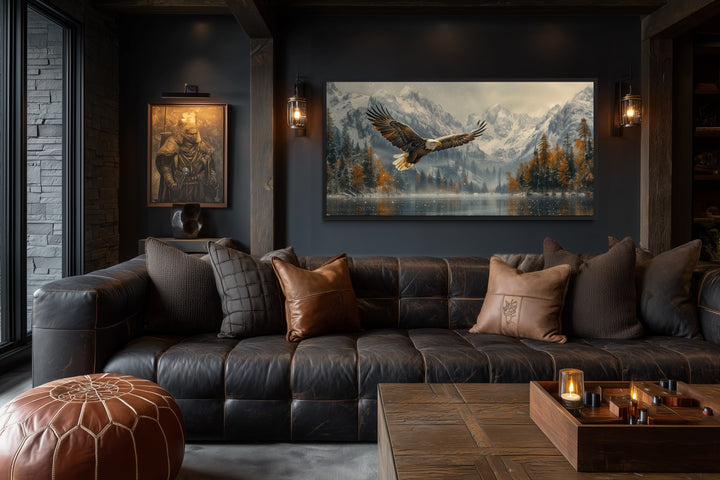 Framed canvas art of a bald eagle flying over a snowy mountain lake in a rustic living room.