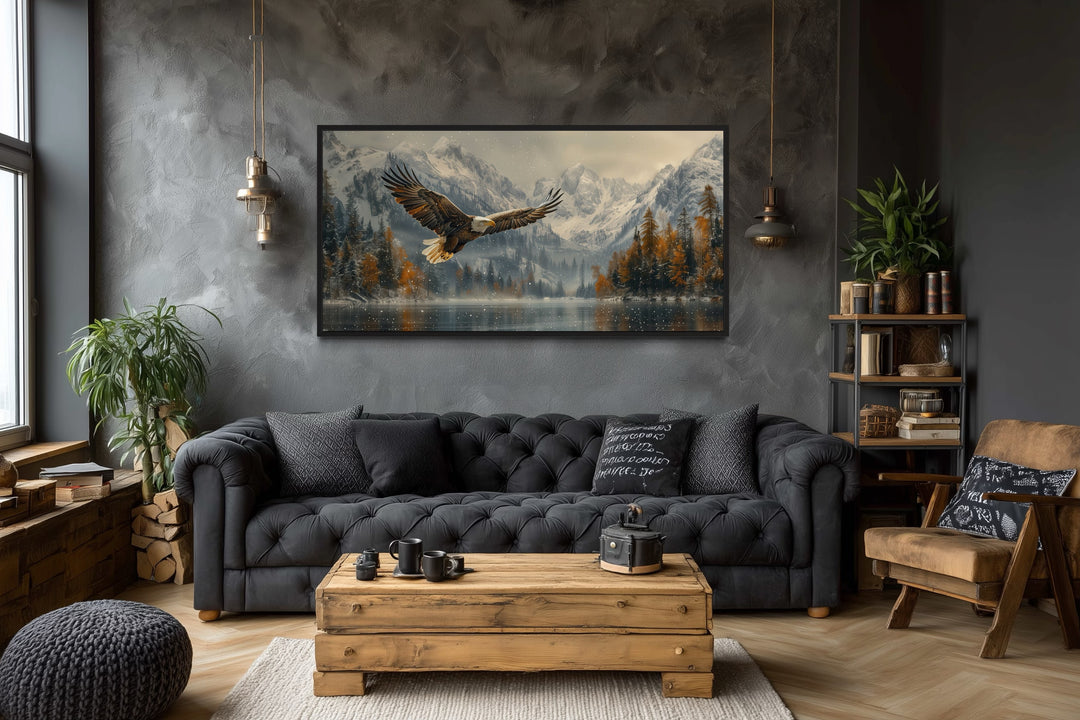 Framed wall art of a bald eagle flying over a snowy mountain lake in a rustic living room.