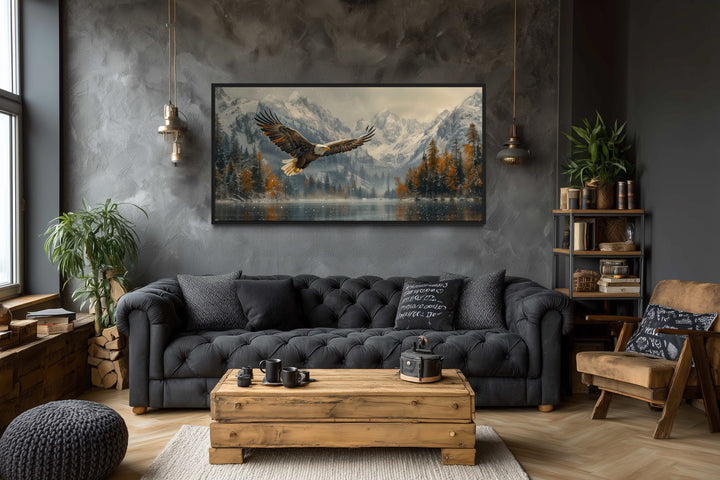 Framed wall art of a bald eagle flying over a snowy mountain lake in a rustic living room.