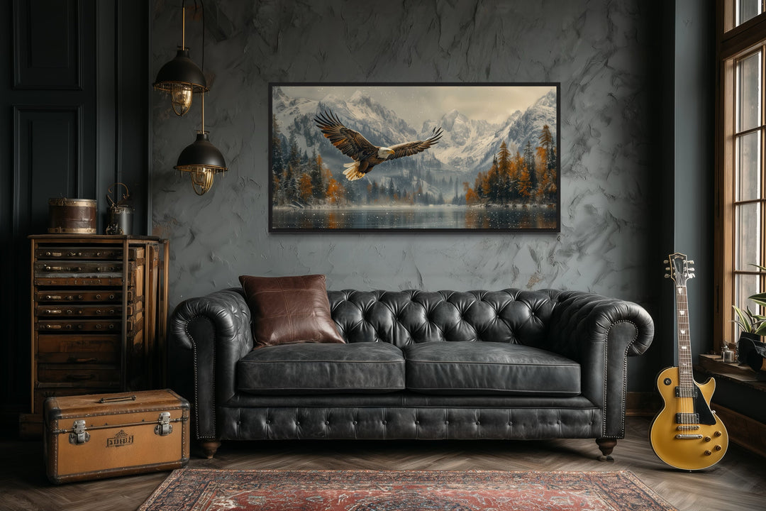 Framed wall art of a bald eagle flying over a snowy mountain lake in a rustic office setting.