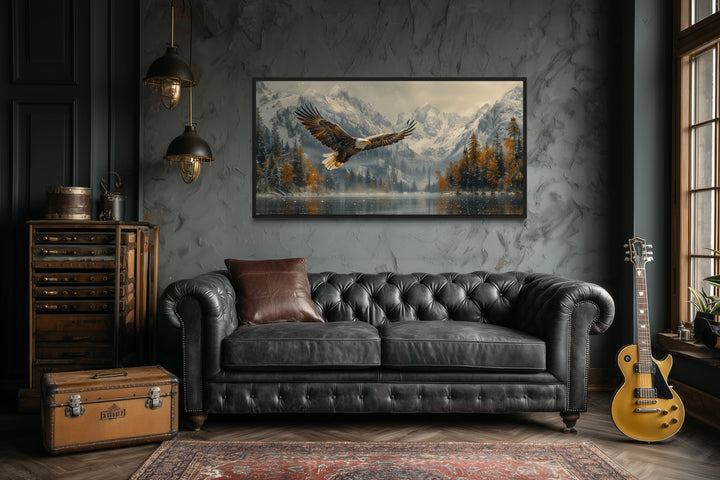 Framed wall art of a bald eagle flying over a snowy mountain lake in a rustic office setting.