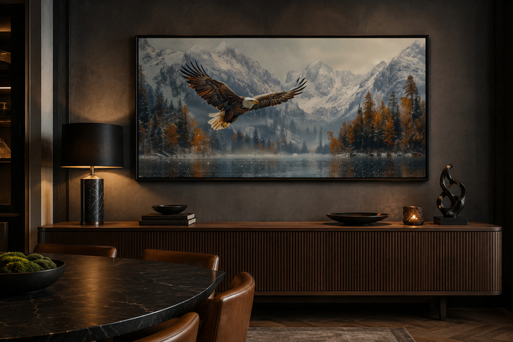 Framed wall art of a bald eagle flying over a snowy mountain lake in a dark, modern office setting.