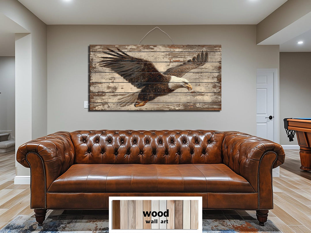 Bald eagle wall art printed on rustic distressed wood planks hanging above a brown leather sofa.