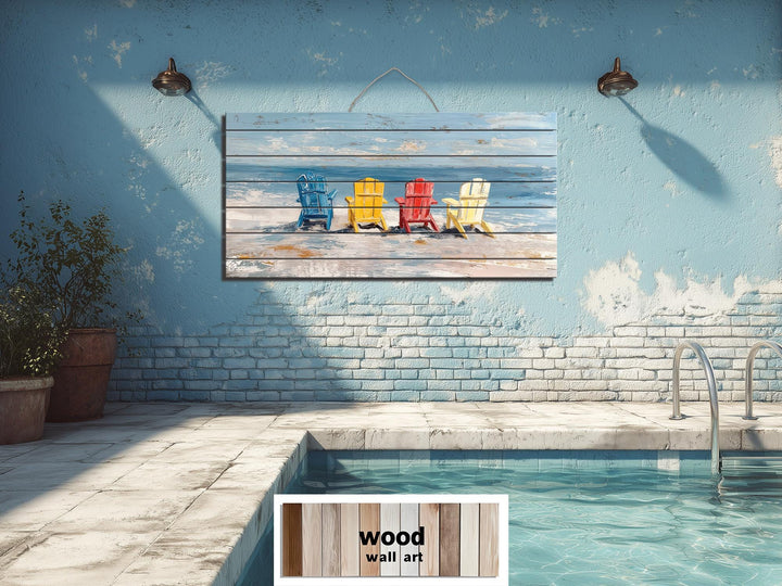 Colorful Adirondack beach chairs printed on a rustic wood wall art panel above a pool.