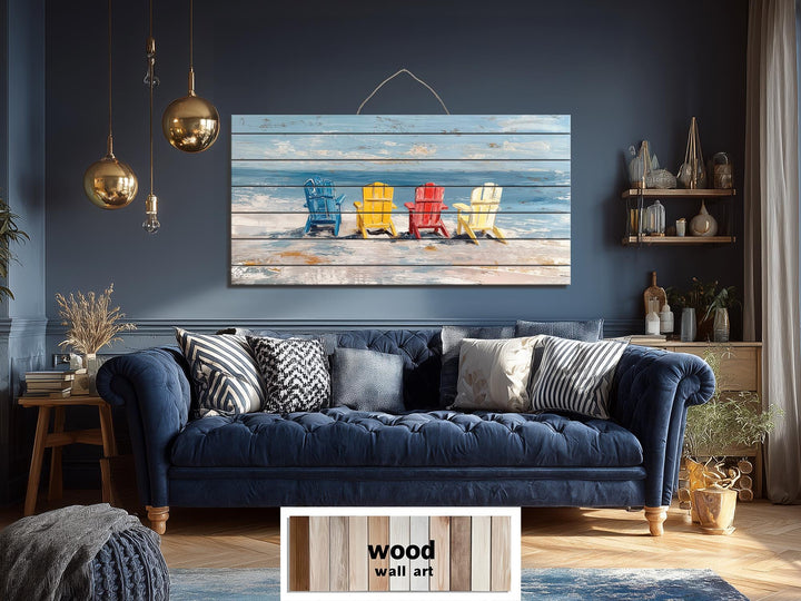 Colorful Adirondack beach chairs printed on a rustic wood wall art panel above a blue sofa.
