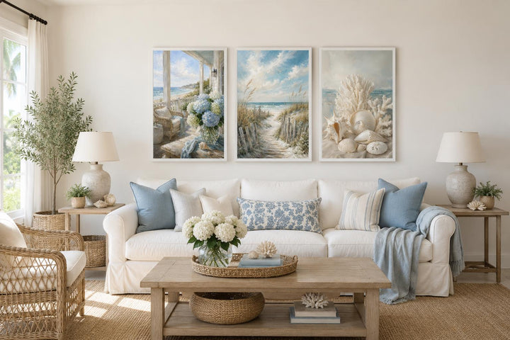 Three-piece framed coastal wall art set featuring beach scenes and shells above a white sofa.