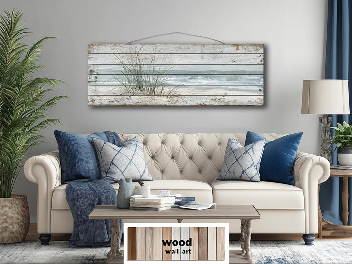 Beach sand dunes and sea grass long narrow wood wall art hanging above a cream sofa.