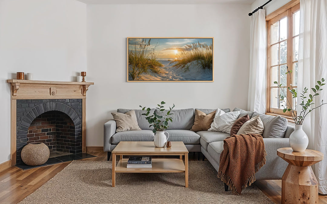 Framed sand dunes canvas wall art featuring a beach sunset above a grey sectional sofa.