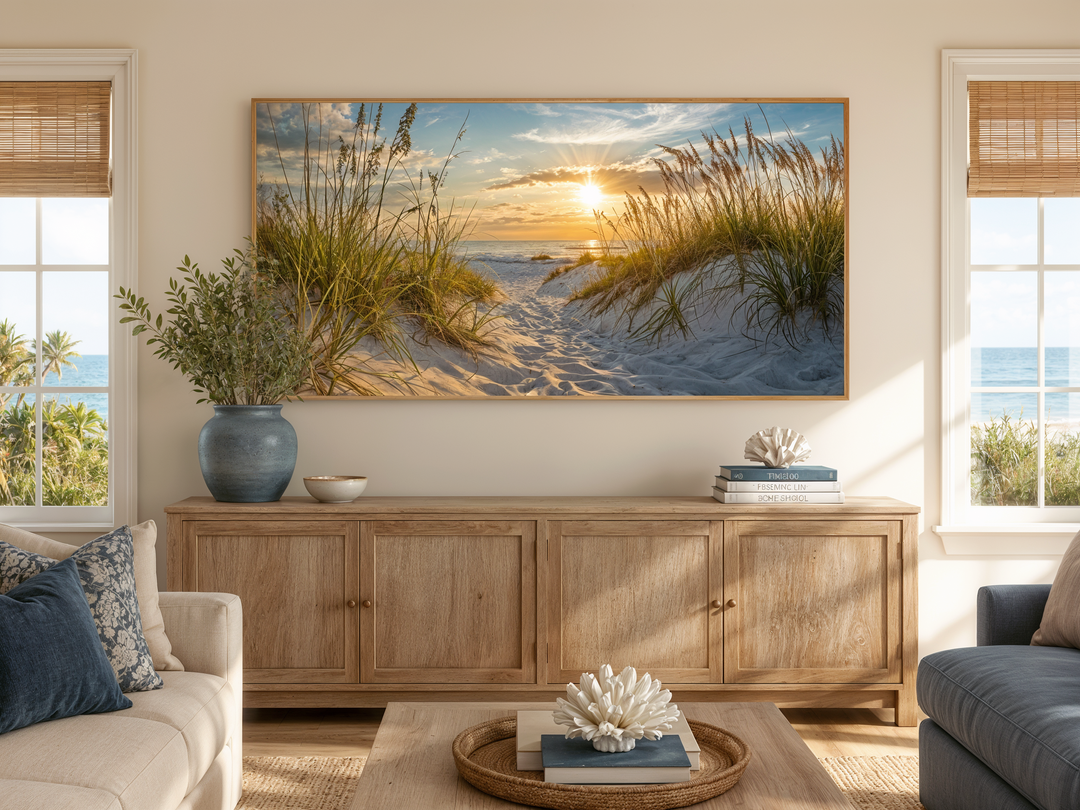 Framed beach sunset wall art featuring sand dunes and a coastal path above a wooden sideboard.