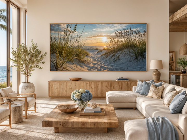 Large framed beach sunset wall art featuring sand dunes and ocean in a coastal living room.