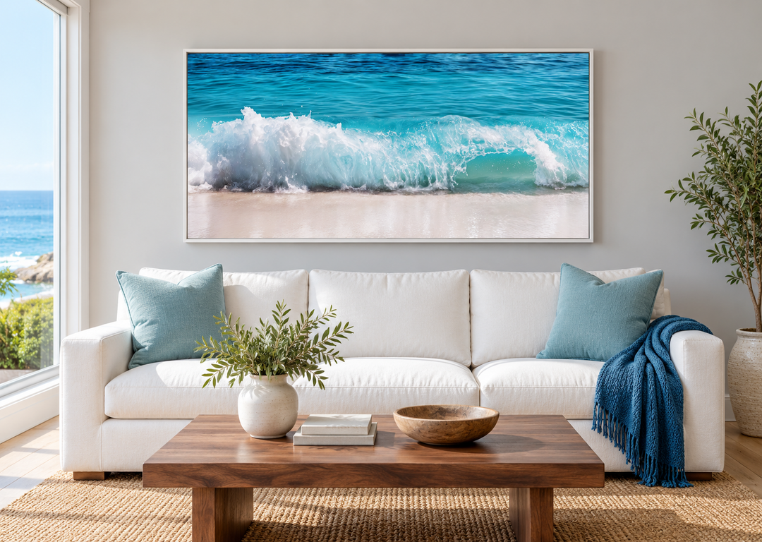 Ocean wave photography coastal framed canvas wall art above a white sofa in a living room.