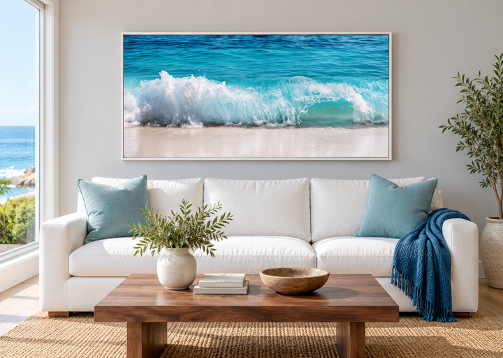 Ocean wave photography coastal framed canvas wall art above a white sofa in a living room.