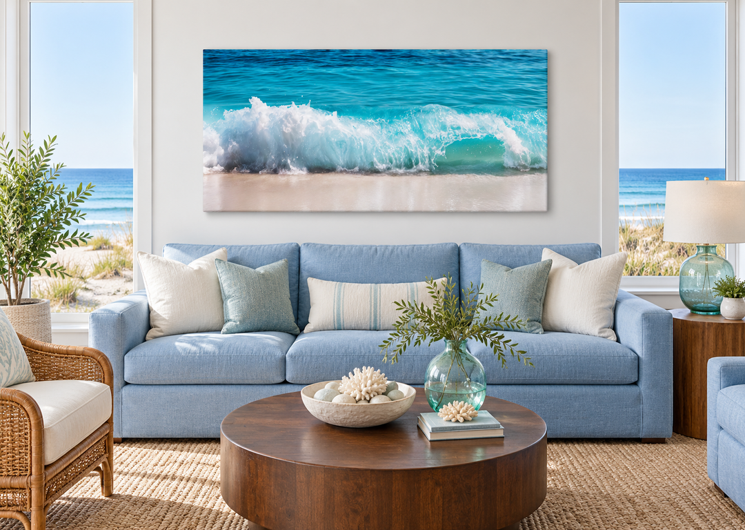 Ocean wave photography coastal framed canvas wall art above a blue sofa in a bright living room.