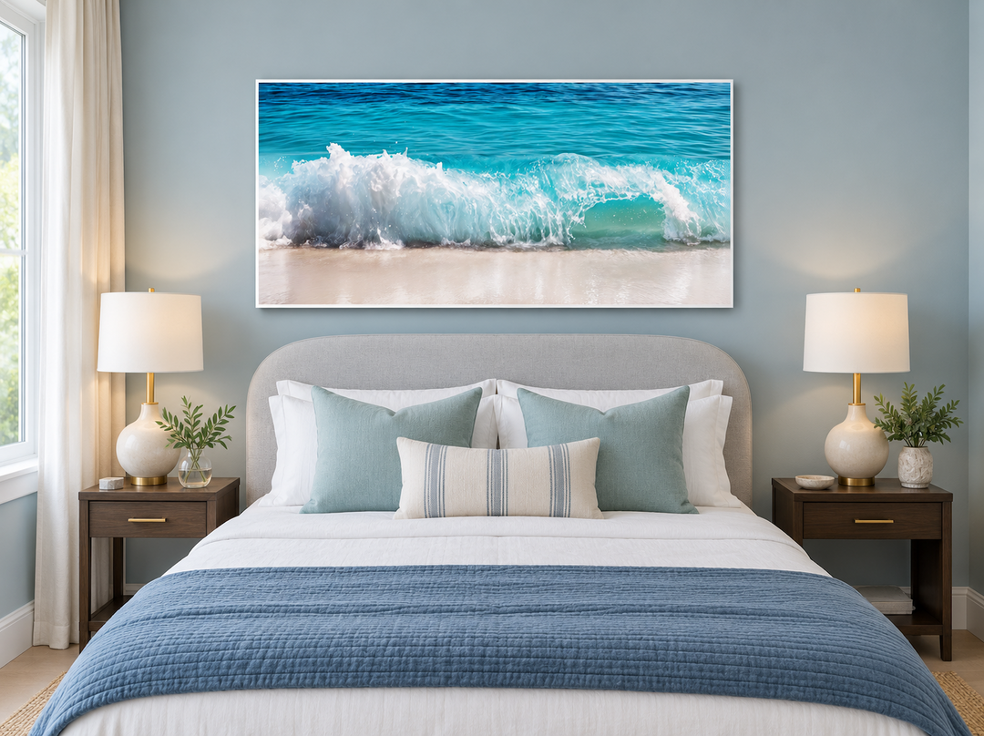 Coastal framed canvas wall art featuring a crashing ocean wave above a bed in a blue bedroom.
