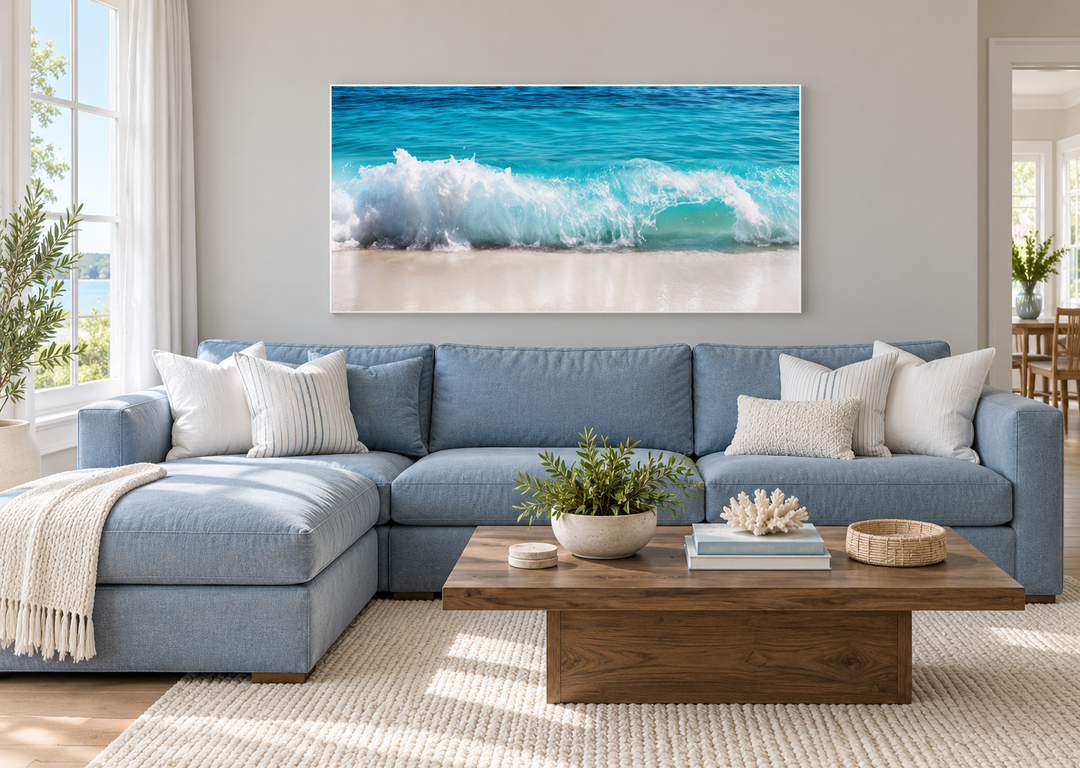 Ocean wave photography coastal framed canvas wall art above a blue sectional in a living room.