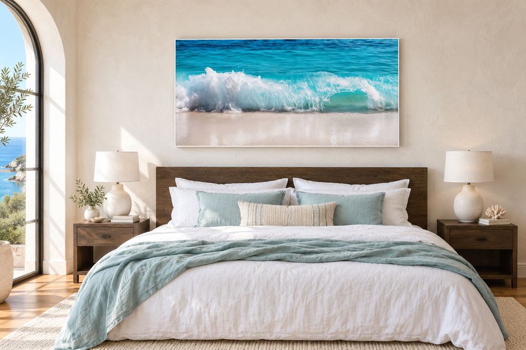 Ocean wave photography coastal framed canvas wall art hanging above a bed in a beach-themed bedroom.