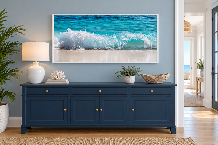 Ocean wave photography coastal framed canvas wall art above a blue sideboard in a beach-themed room.