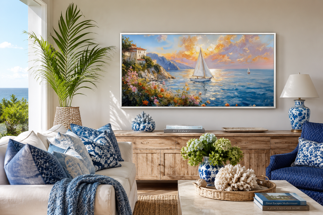 Modern coastal framed canvas print of a sunset seascape with sailboats above a wooden sideboard.