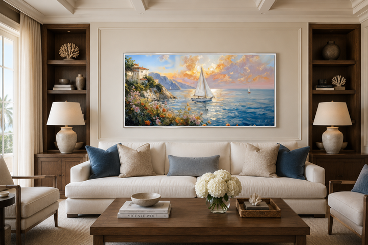 Modern coastal framed canvas print of a sunset seascape with sailboats above a white sofa.