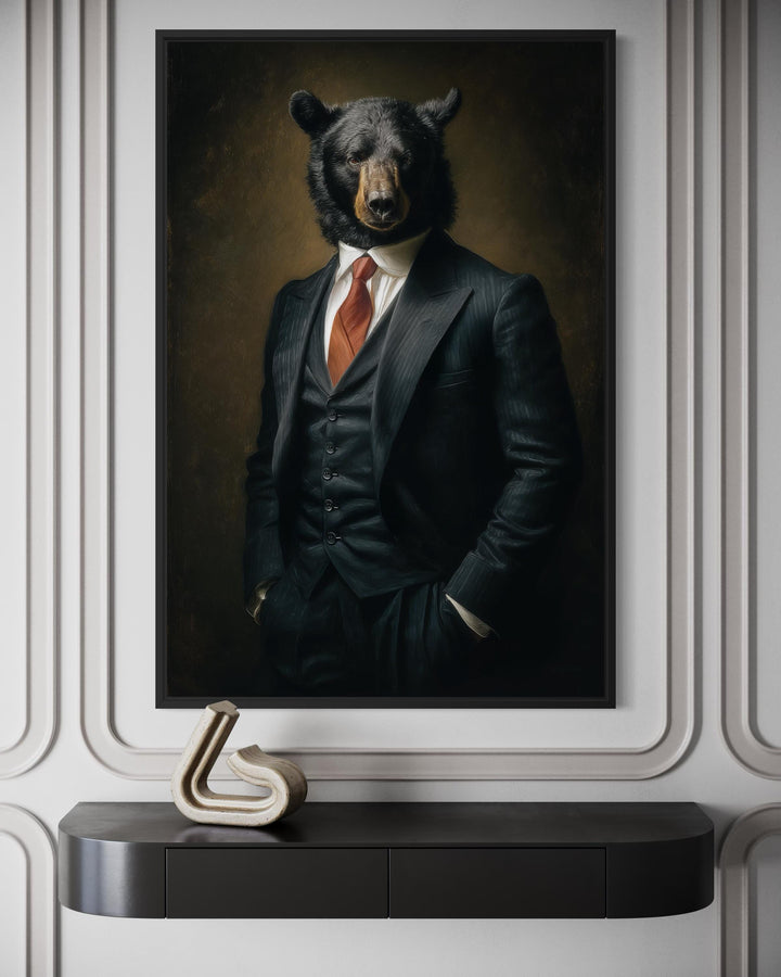 A framed canvas painting of a black bear in a three-piece suit hanging above a modern console table.