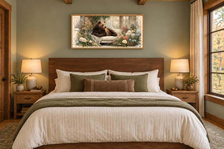 Bear on Couch Floral Canvas Wall Art in a wooden frame above a bed in a rustic bedroom.