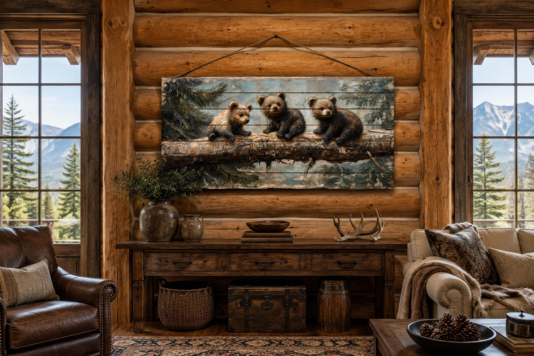 Rustic wood panel print of three bear cubs on a log, hanging in a log cabin living room.