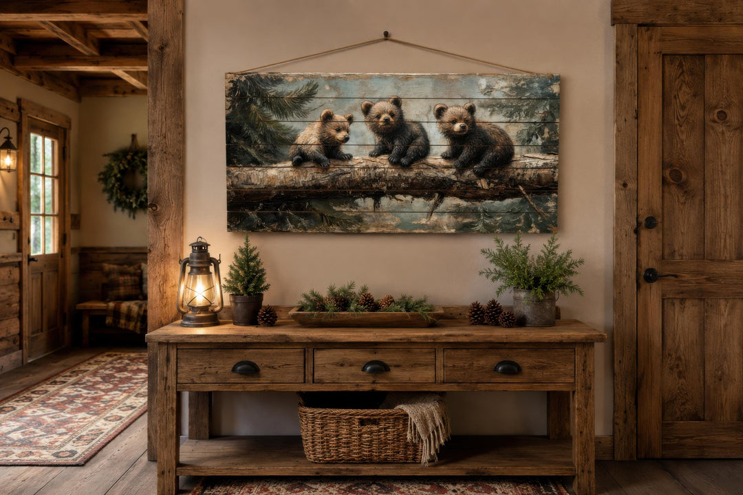 Rustic wood panel print of three bear cubs on a log, hanging above a wooden console table.