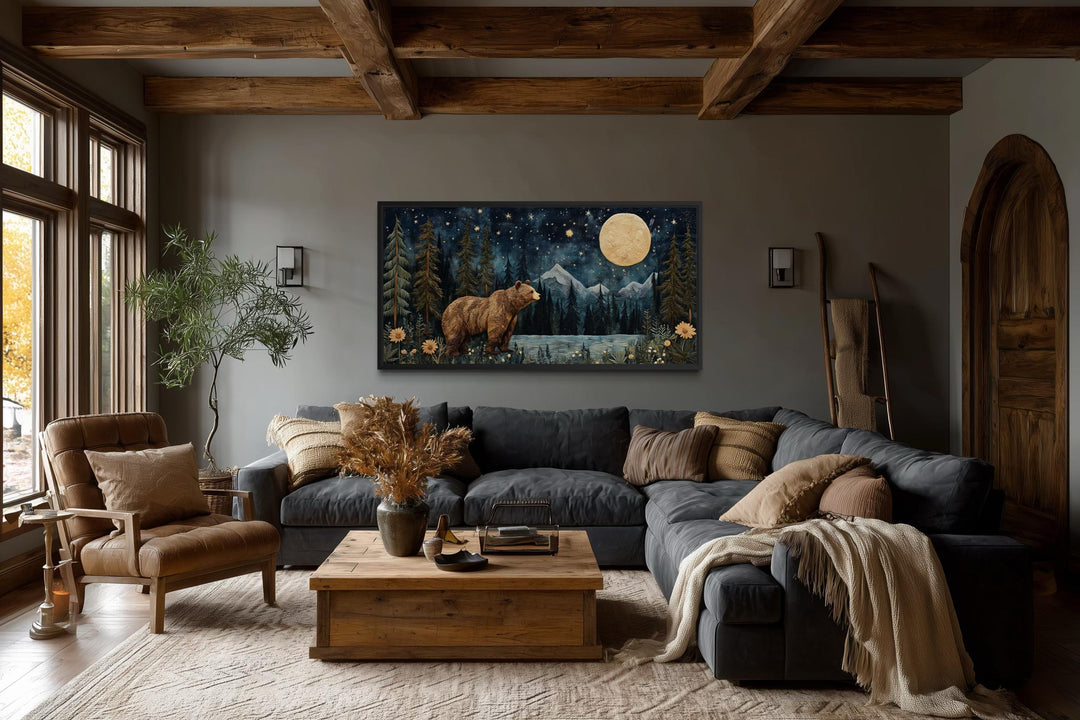 Bear in night forest wall art canvas print with full moon and mountain landscape above a sofa.