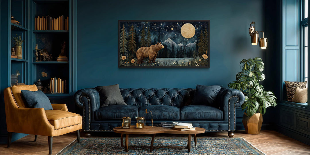 Bear in night forest wall art canvas print with full moon and mountain landscape above a blue sofa.