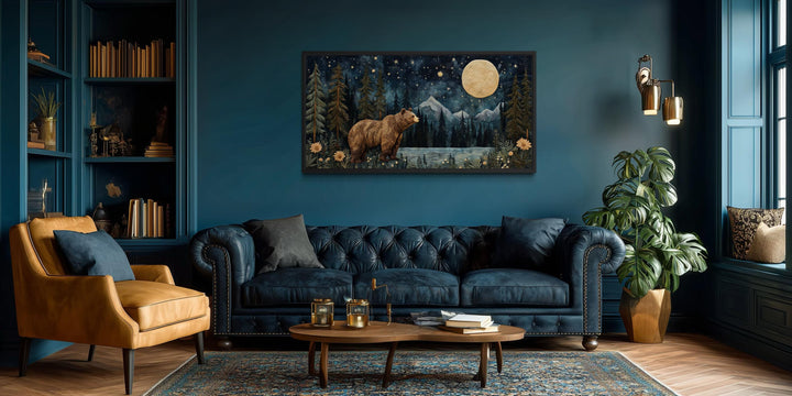 Bear in night forest wall art canvas print with full moon and mountain landscape above a blue sofa.