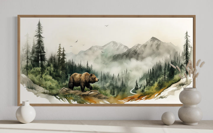 Watercolor bear in a misty mountain forest landscape wall art in a wooden frame.