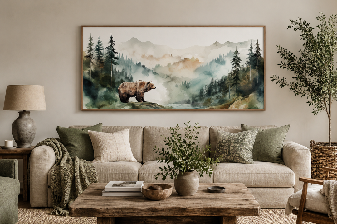 Bear in the wilderness forest watercolor framed canvas wall art hanging above a beige sofa.
