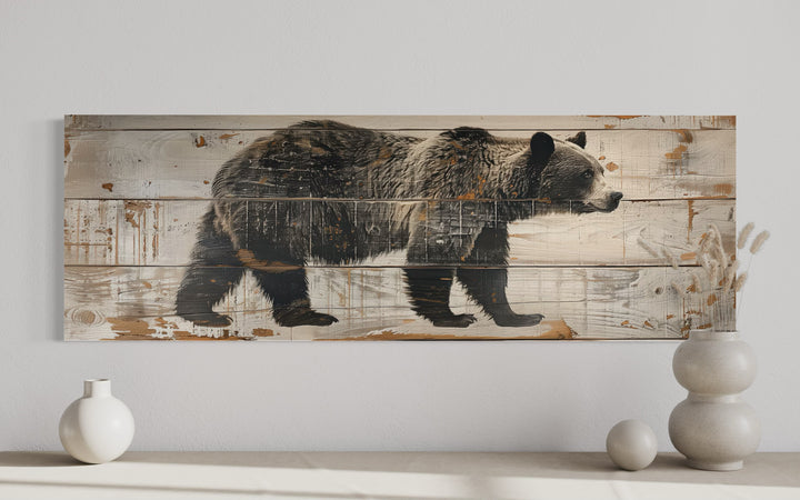 Long horizontal canvas wall art of a bear painted on rustic wood planks for cabin decor.